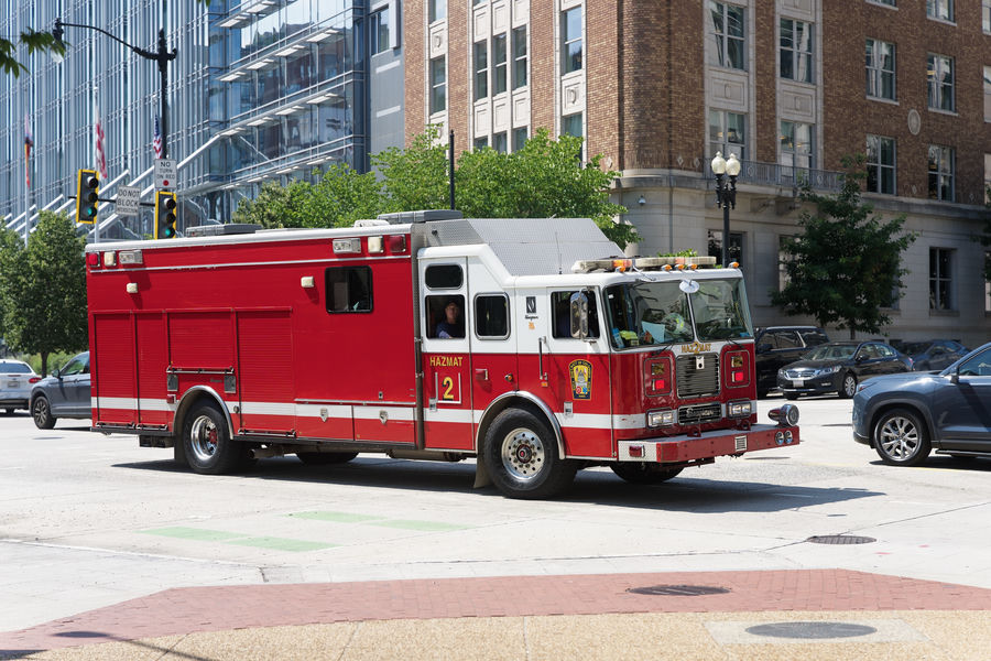A red fire truck on a city street, rendered with OMR Color